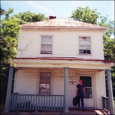 A person standing in front of a house

Description automatically generated