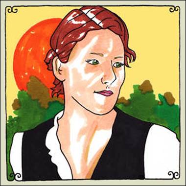 A person with red hair and a black vest

Description automatically generated