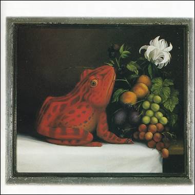 A red frog sitting next to a fruit and a white flower

Description automatically generated