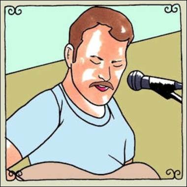 A person with a mustache and a microphone

Description automatically generated