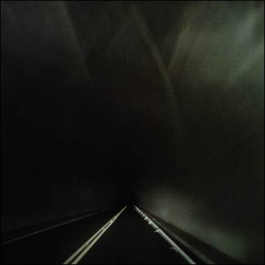 A dark tunnel with a road and light

Description automatically generated with medium confidence