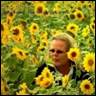 A person in a field of sunflowers

Description automatically generated