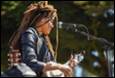 A person with dreadlocks playing guitar

Description automatically generated with medium confidence