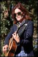 A person with red hair and sunglasses playing a guitar

Description automatically generated with low confidence