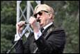 A person in a suit and sunglasses singing into a microphone

Description automatically generated with medium confidence