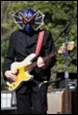 A person wearing a mask playing a guitar

Description automatically generated with medium confidence