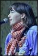 A person with a scarf and a microphone

Description automatically generated