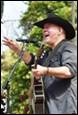 A person in a cowboy hat singing into a microphone

Description automatically generated