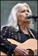 A person with white hair and a guitar

Description automatically generated