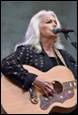 A person with white hair playing guitar

Description automatically generated