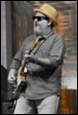 A person wearing a hat and sunglasses playing a guitar

Description automatically generated with low confidence