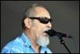 A person with sunglasses and a beard singing into a microphone

Description automatically generated with low confidence