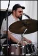 A person playing drums with a microphone

Description automatically generated with low confidence