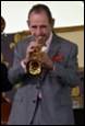 A person in a suit playing a trumpet

Description automatically generated with medium confidence