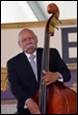 A person in a suit and tie playing a double bass

Description automatically generated with medium confidence
