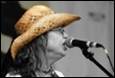 A person wearing a cowboy hat singing into a microphone

Description automatically generated with medium confidence