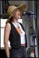 A person wearing a cowboy hat and a black vest singing into a microphone

Description automatically generated with low confidence