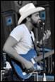 A person in a cowboy hat playing a guitar

Description automatically generated with medium confidence
