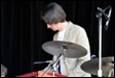 A person playing drums on stage

Description automatically generated with low confidence
