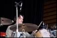 A person playing drums on stage

Description automatically generated with medium confidence