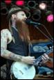 A person with long beard playing a guitar

Description automatically generated