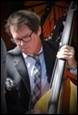 A person in a suit and tie playing a cello

Description automatically generated
