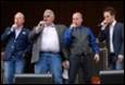 A group of men singing on stage

Description automatically generated