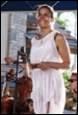 A person in a white dress playing a violin

Description automatically generated