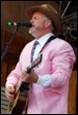 A person in a pink jacket and hat playing guitar

Description automatically generated