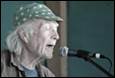An old person with a green hat singing into a microphone

Description automatically generated with low confidence
