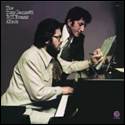 A person sitting at a piano with another person in front of him

Description automatically generated