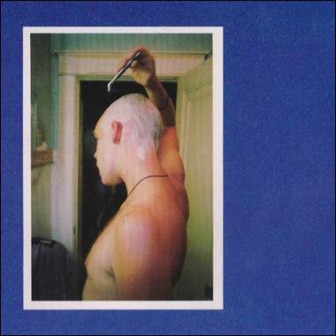 A person shaving his head

Description automatically generated