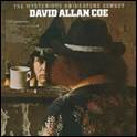 A person in cowboy hat looking at a person in a mug

Description automatically generated