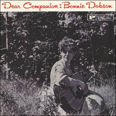 A person sitting in the grass with a guitar

Description automatically generated