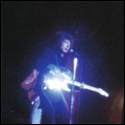 A person playing a guitar on a stage

Description automatically generated