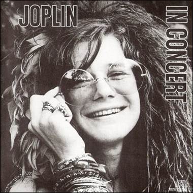 A person smiling with glasses and feathers

Description automatically generated