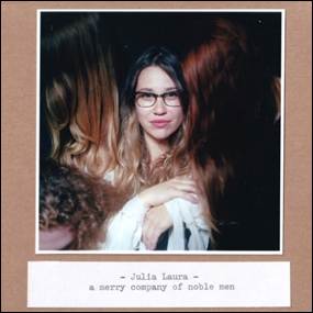 A person with glasses and a white scarf
Description automatically generated