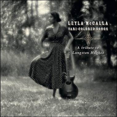 A person in a dress holding a guitar
Description automatically generated