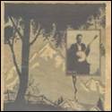 A person playing a banjo in front of a mountain

Description automatically generated