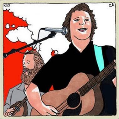 A person playing guitar and singing with a person behind him

Description automatically generated