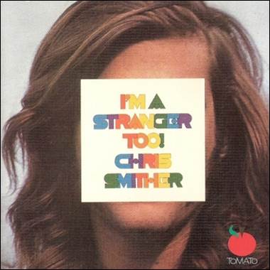 A person with long hair covering his face with a white square with colorful text

Description automatically generated