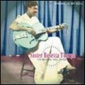 A person sitting on a chair playing a guitar

Description automatically generated