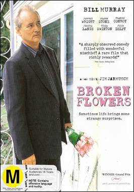 A person in a suit holding a flower
Description automatically generated