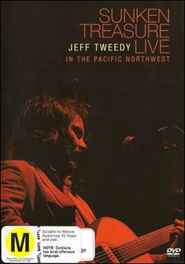 A person playing a guitar on a stage

Description automatically generated