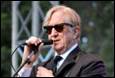 A person in a suit and tie holding a microphone

Description automatically generated with medium confidence