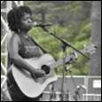 A person playing guitar on stage

Description automatically generated