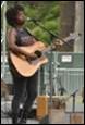 A person playing guitar on stage

Description automatically generated