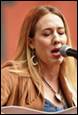 A person singing into a microphone

Description automatically generated