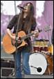 A person playing guitar on stage

Description automatically generated