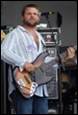 A person holding a guitar

Description automatically generated